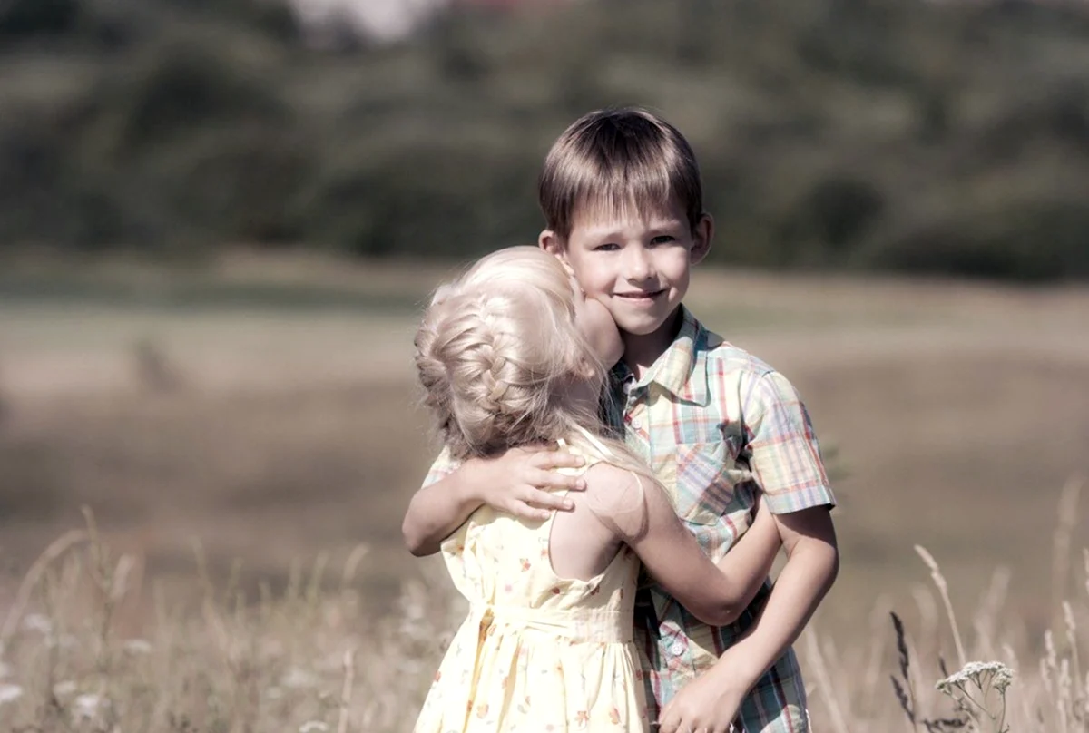 Маленькая девочка обнимает мальчика. Картинка