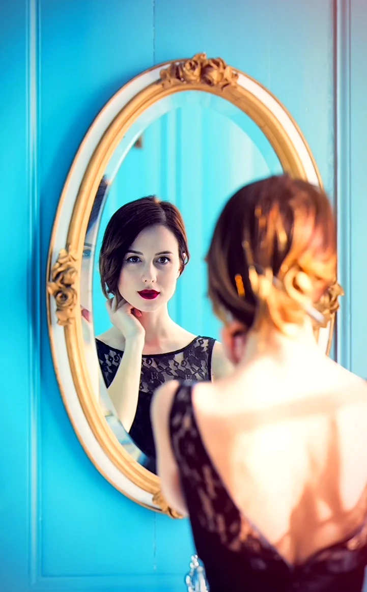 Отражение женщины в зеркале. Красивая девушка
