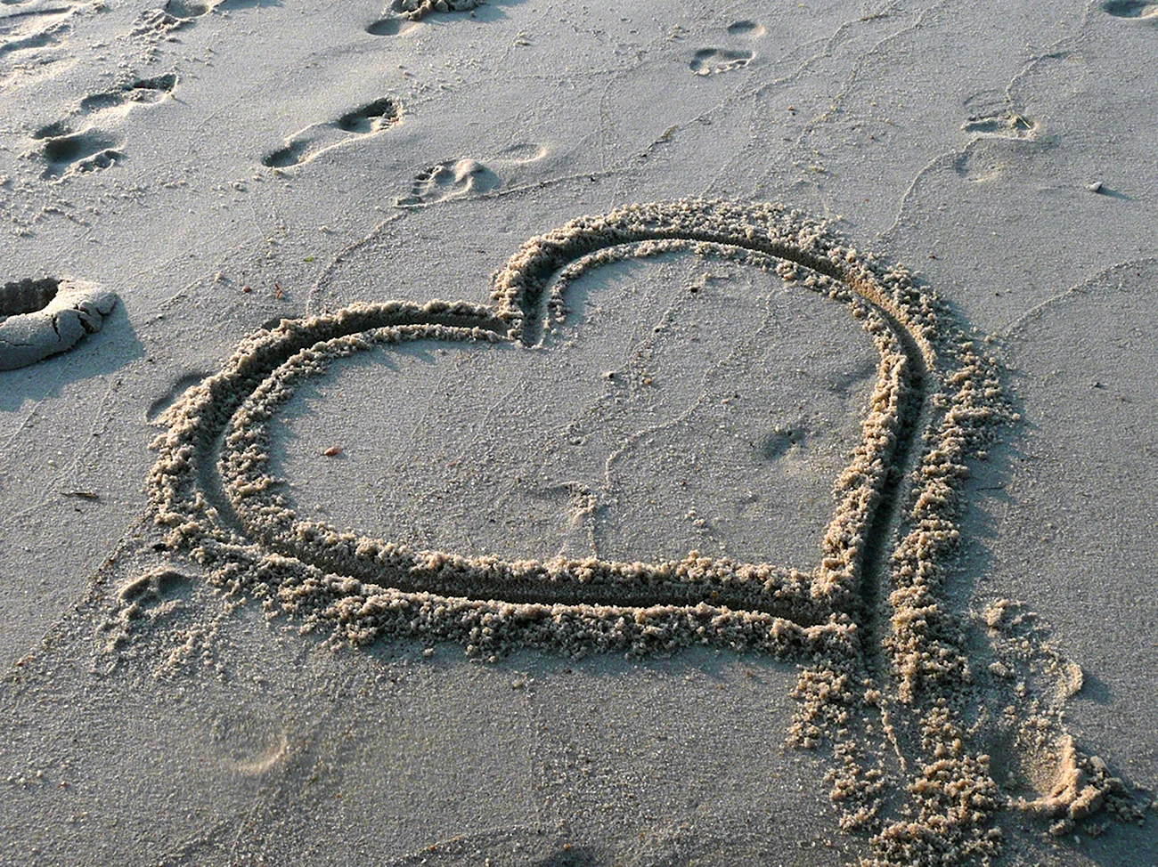 Сердце на песке у моря. Красивая картинка